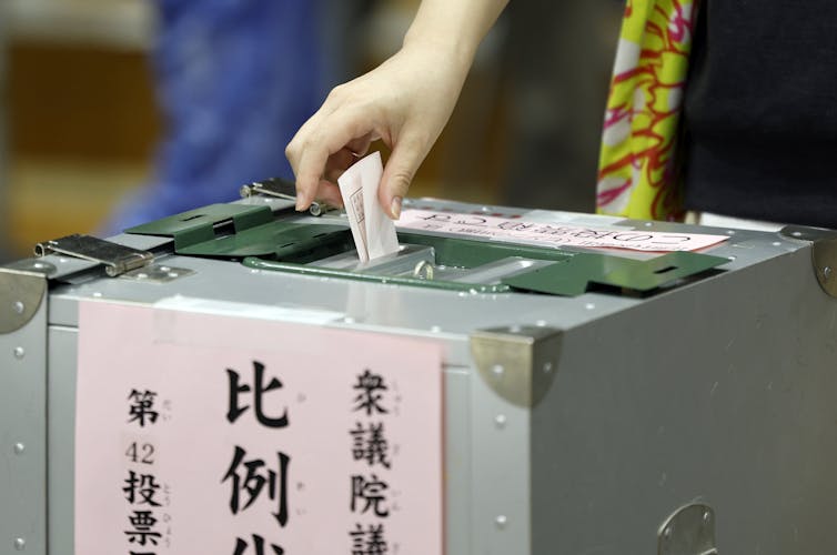 A woman casting her ballot in Japan.