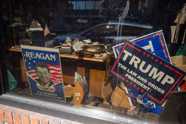 Signs showing Ronald Reagan and Donald Trump.