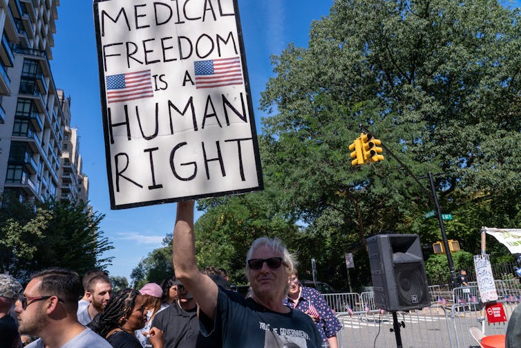 A man holds a sign that says