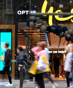 People walking in front of an Optus store