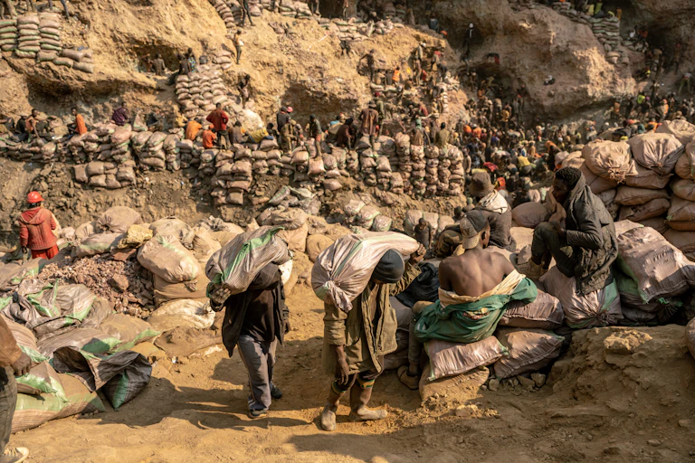 Miners carry bags of ore in the copper-cobalt Shabara artisanal mine near the town of Kolwezi, Lualaba, Democratic Republic of Congo.