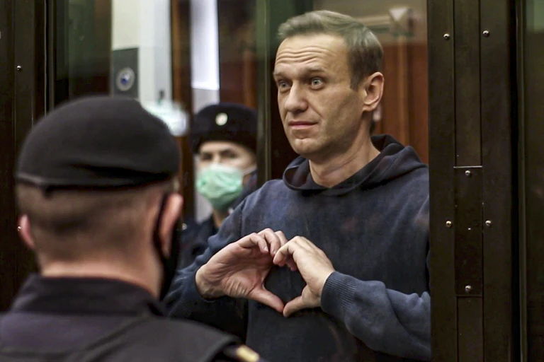 A man, Alexei Navalny, makes a heart-shaped symbol with his fingers.