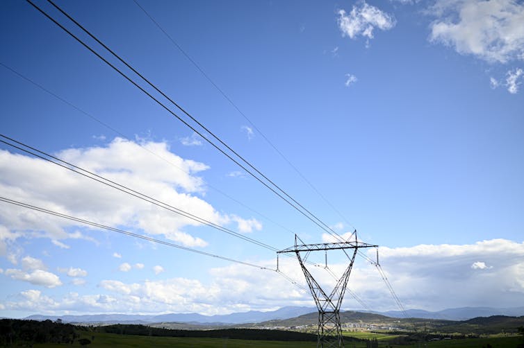 power lines and tower against blue sky