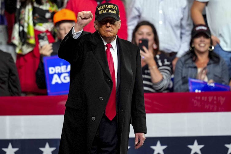 Trump raises his fist to the crowd at a rally.
