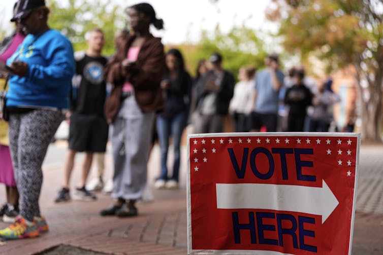 People stand in line during the last day of early voting, Saturday, Nov. 2, 2024, in Charlotte, N.C