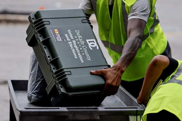 Officials with the DeKalb County Voter Registration and Elections office distribute polling site materials