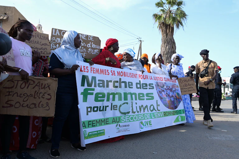 Women marching and holding up a banner for climate justice