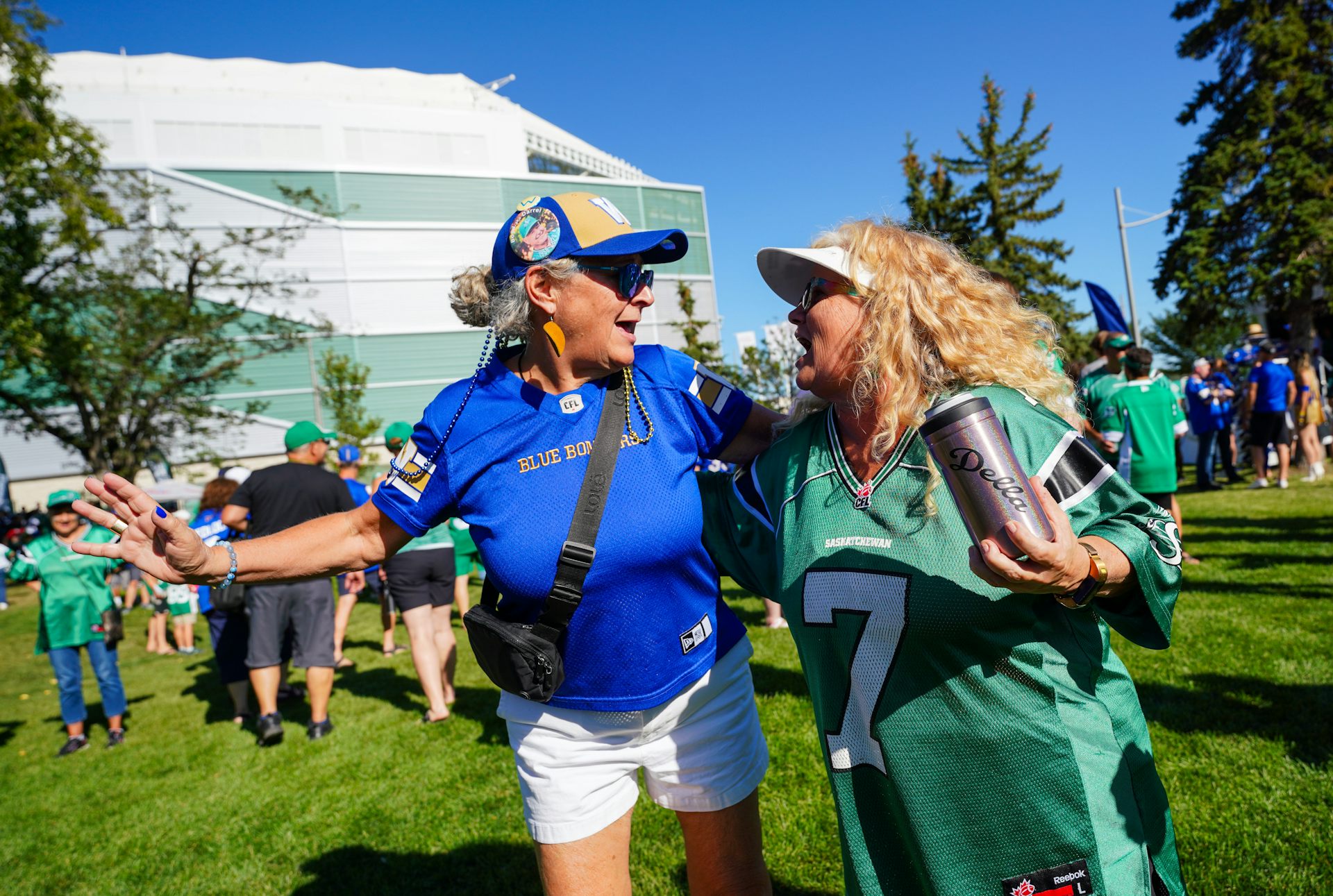 Two women dance outside a football stadium