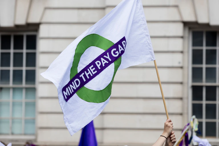 flag bearing the slogan mind the pay gap