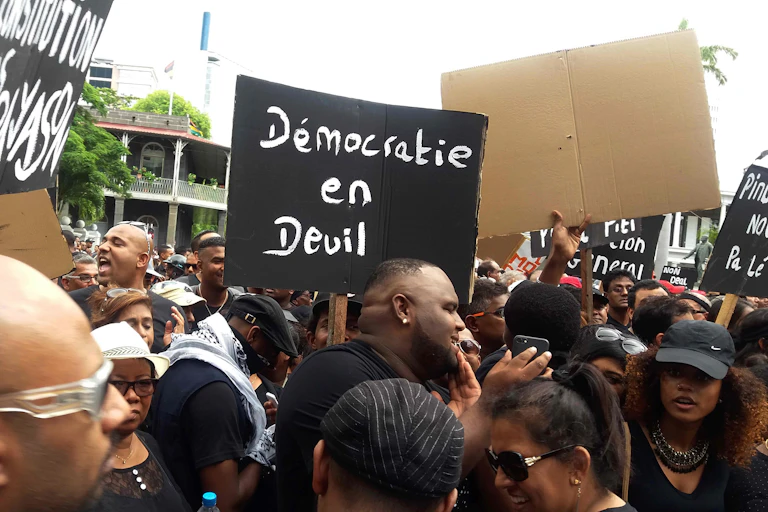 Protesters hold a placard reading 'Democracy in distress'