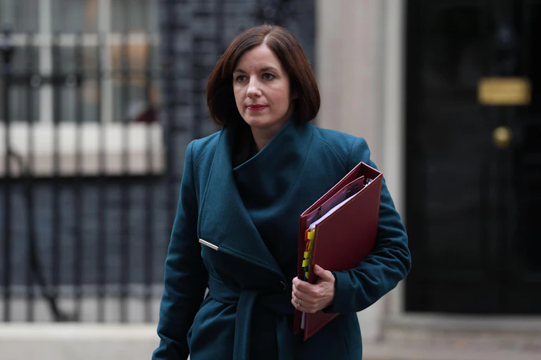Bridget Phillipson in blue coat with red folder