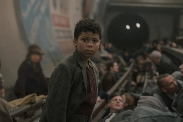 A young black boy in an underground station during the blitz.
