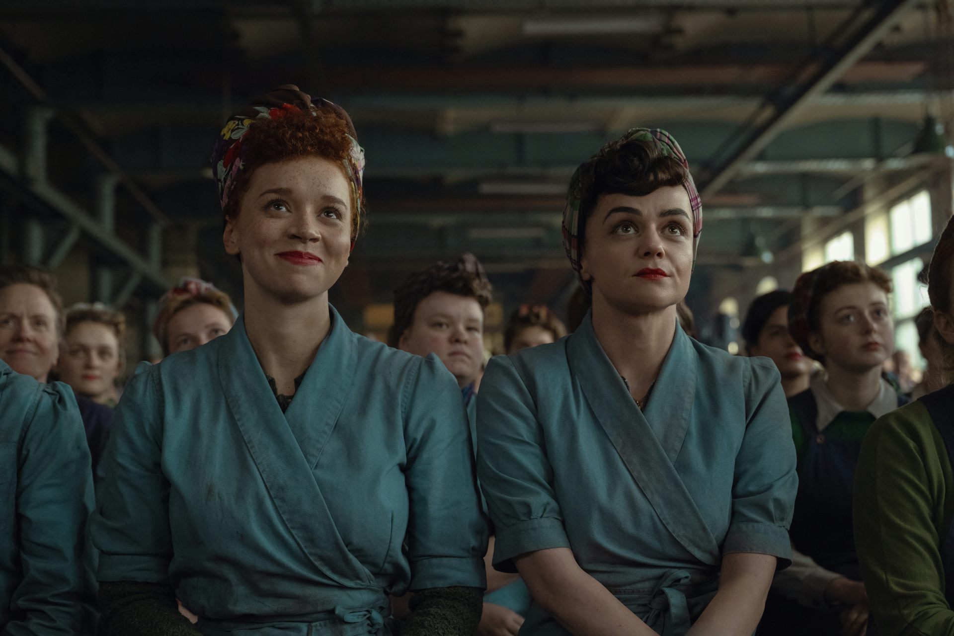 Two young women during the second-world war, dressed in overalls in a munitions factory.
