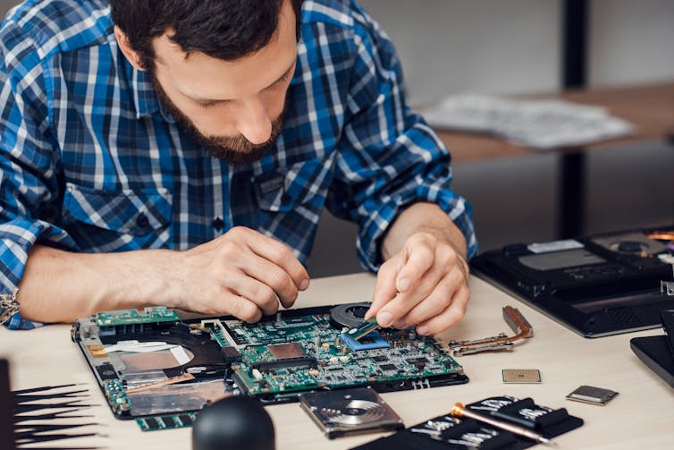 a man works on an electronic board