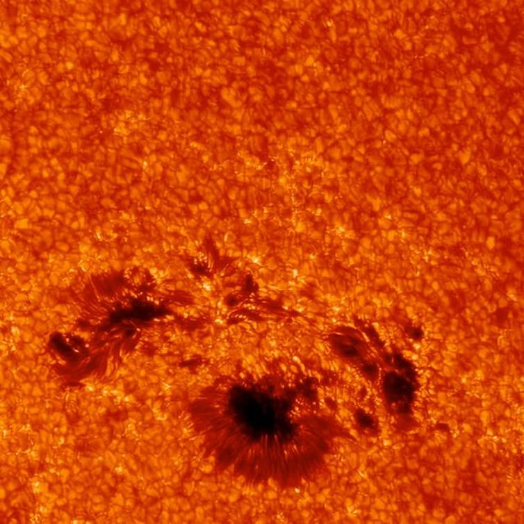 an orange surface with black dots in the lower third