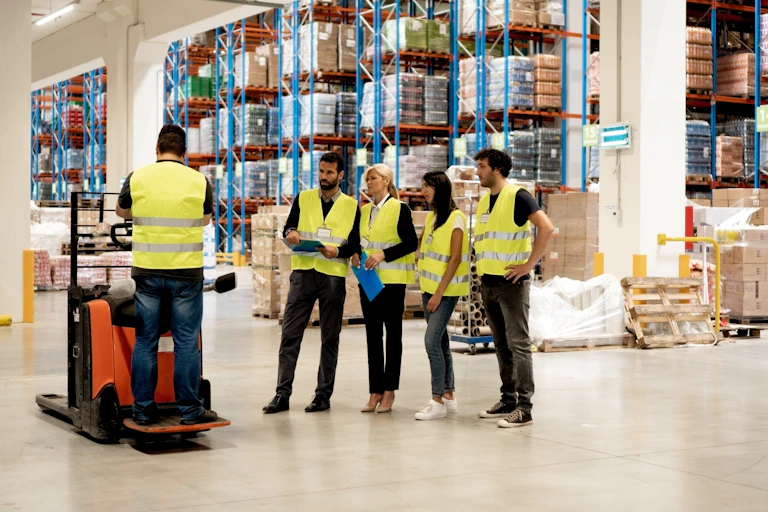 Des ouvriers debout devant des étages de marchandises