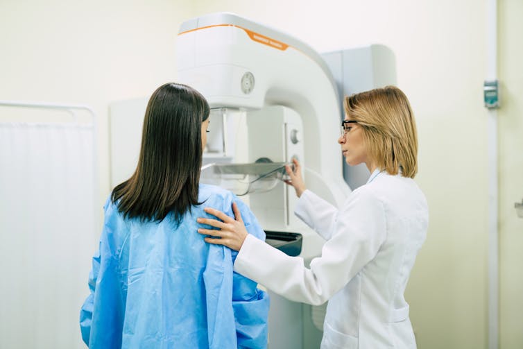 Young woman having mammogram with radiographer or doctor