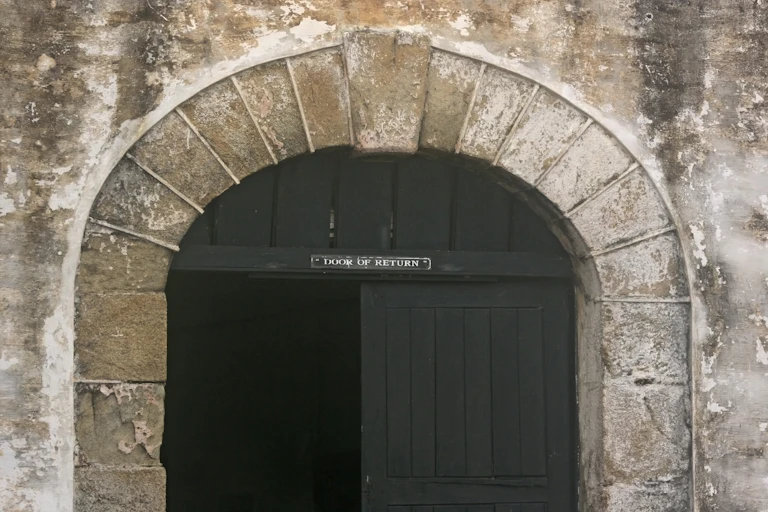A large wooden door in an archway in a stone wall