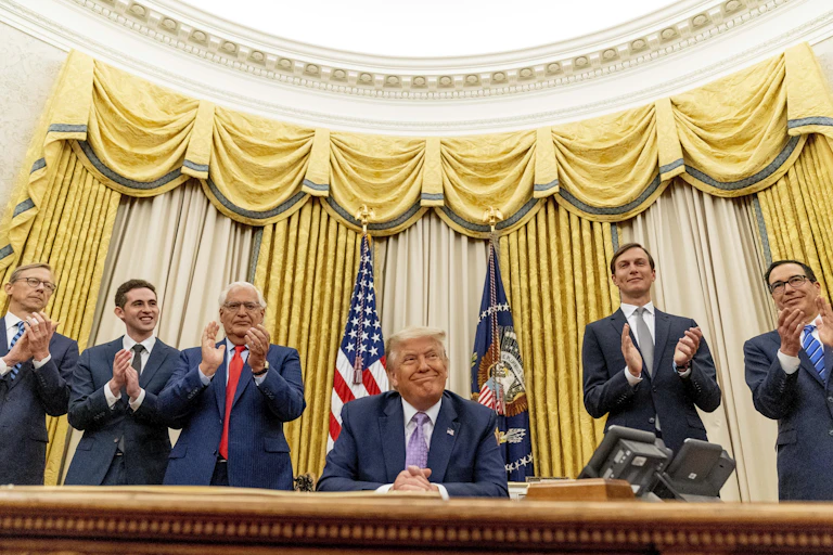 Trump sits in the Oval Office surrounded by men in suits