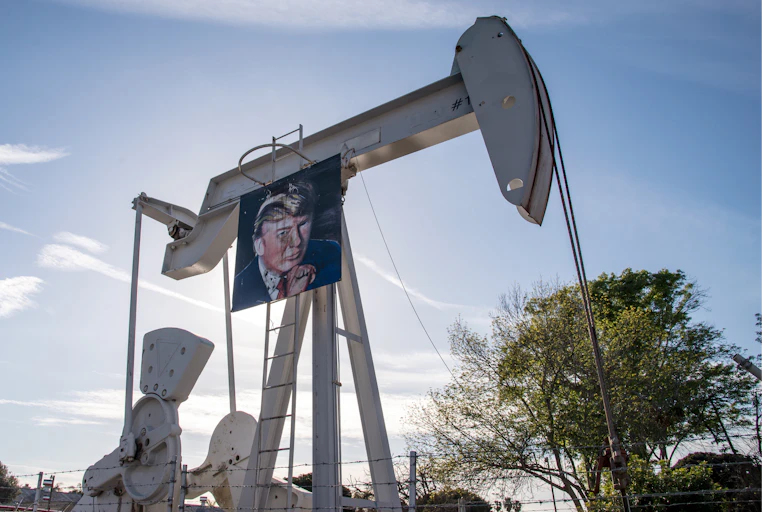 Huntington Beach, Californie - 24 janvier 2017. Des travailleurs du secteur pétrolier célèbrent la victoire présidentielle de Donald Trump et le renouvellement de son partenariat avec l'industrie pétrolière en accrochant sa photo sur les pompes à pétrole.