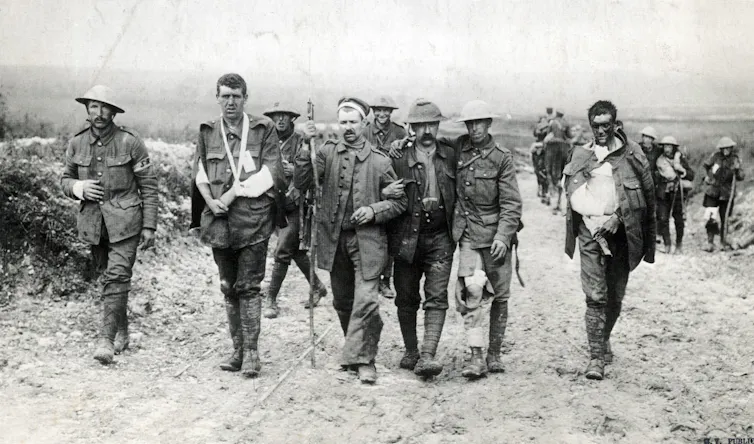 Wounded British soldiers and German prisoners walking together.