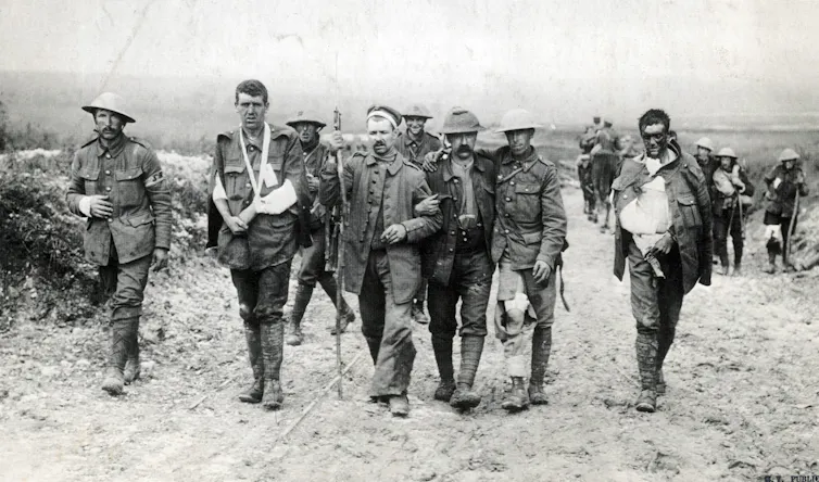 Wounded British soldiers and German prisoners walking together.