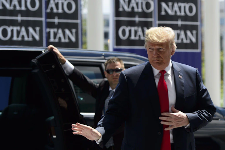 Donald Trump at a Nato meeting in a suit.