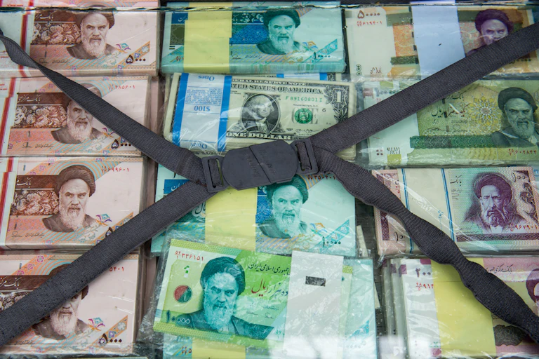 A briefcase of banknotes, most depicting a man in Iranian dress.