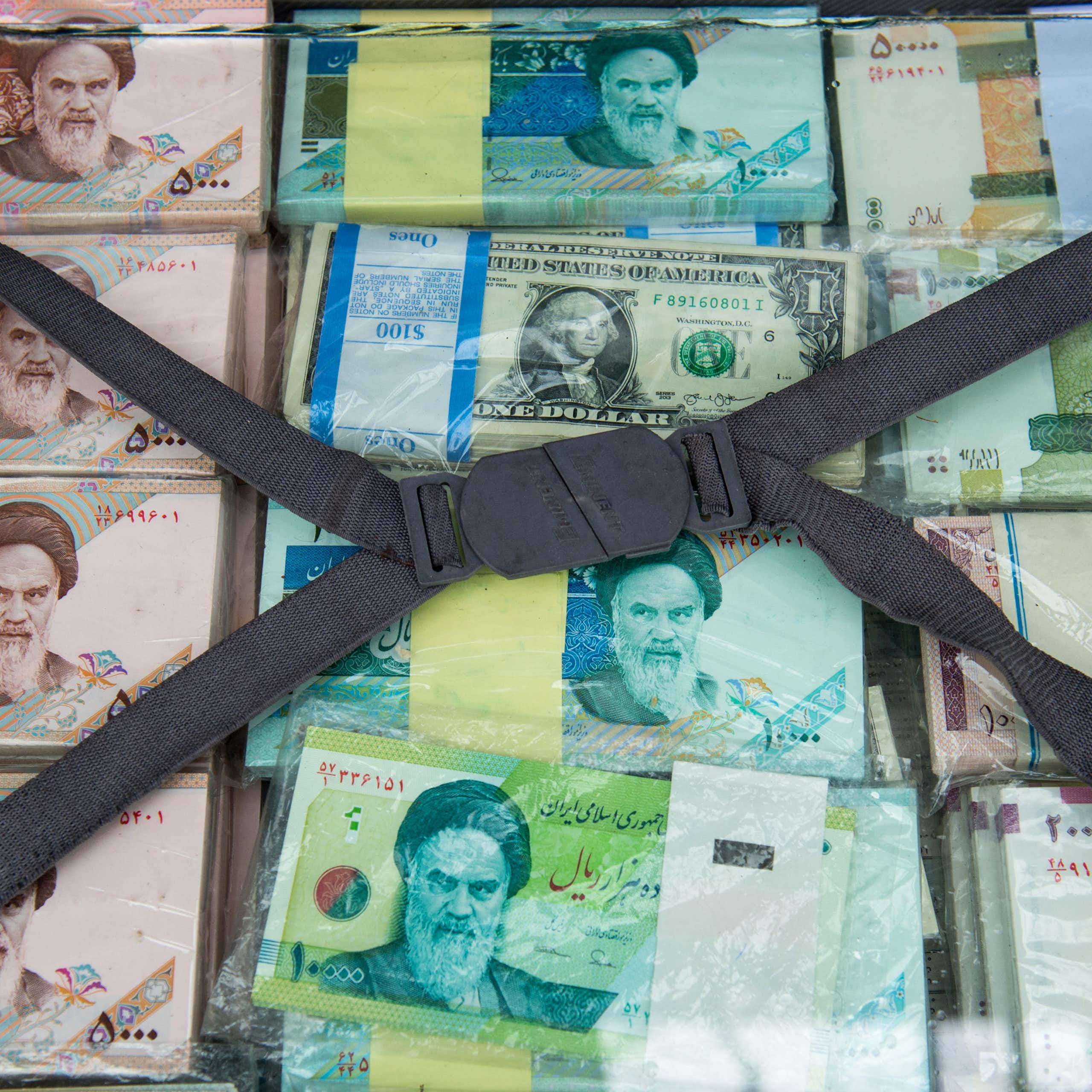 A briefcase of banknotes, most depicting a man in Iranian dress.