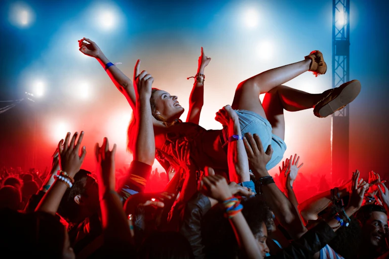 Young person crowd surfing at outdoor gig or music festival