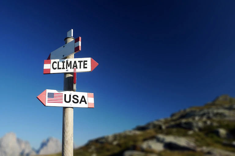 Road sign pointing to climate and USA in two different directions