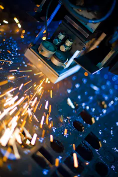 Laser cutting machine creates sparks as it cuts metal