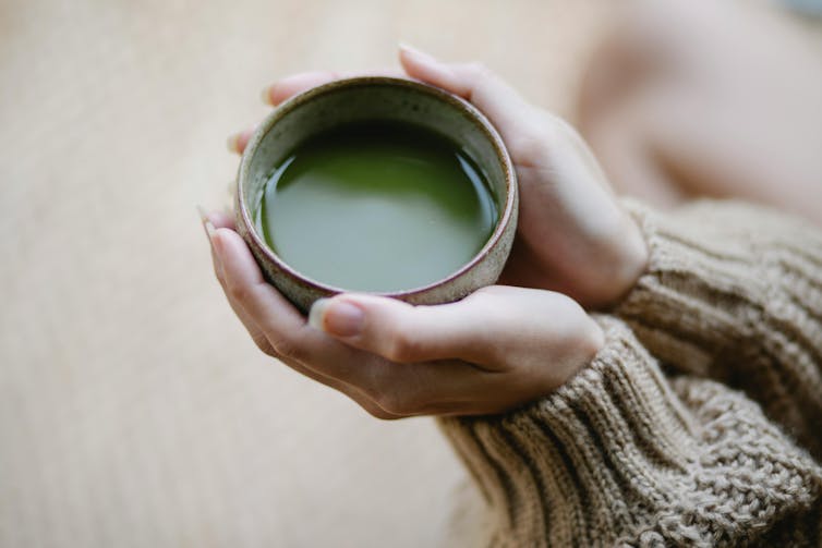 Hands holding a cup of matcha.