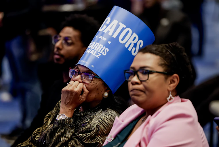 Two women watch nervously as they await the results of the 2024 US election.