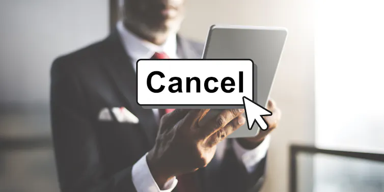 Person holding laptop, with rectangle cancel button over image.