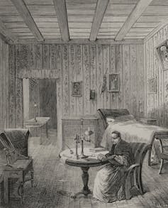 A black and white engraving of a man in robes seated in a high room with wooden walls and simple furnishings.
