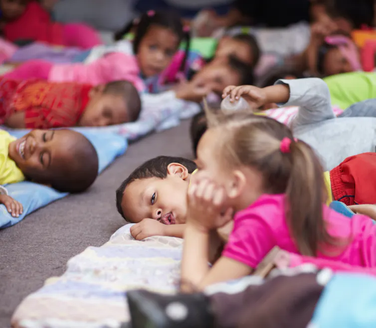 Preschool children all lying down and getting ready for naptime