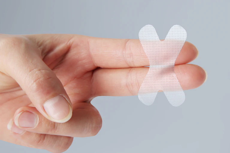A person with mouth tape across two of their fingers.