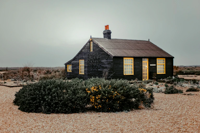 A black cottage on a beach
