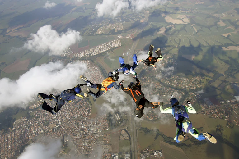 A group of skydivers hover above the Earth.
