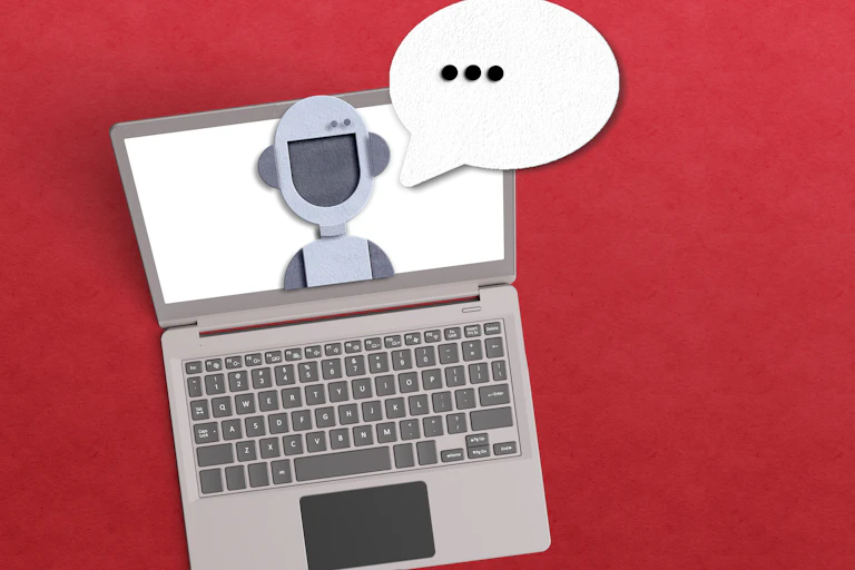 stylized image of a robot head on a laptop screen with a cartoon speech bubble