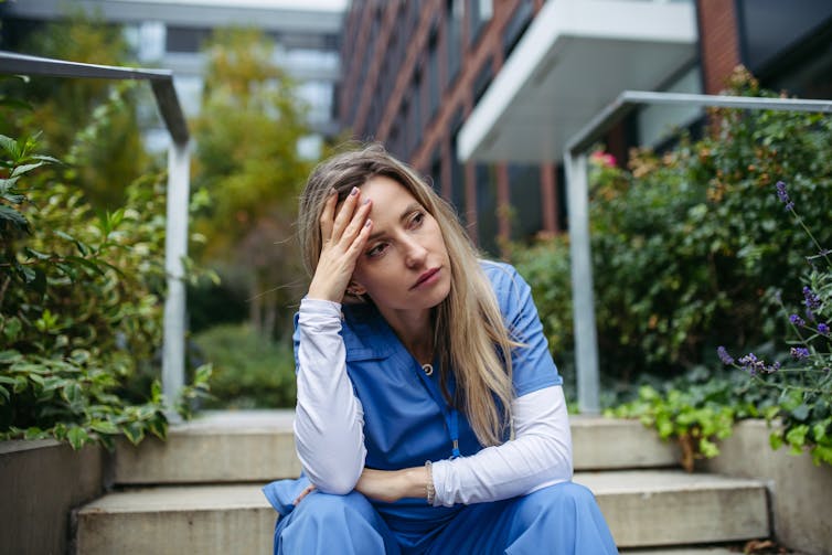 A doctor looks stressed and overwhelmed.