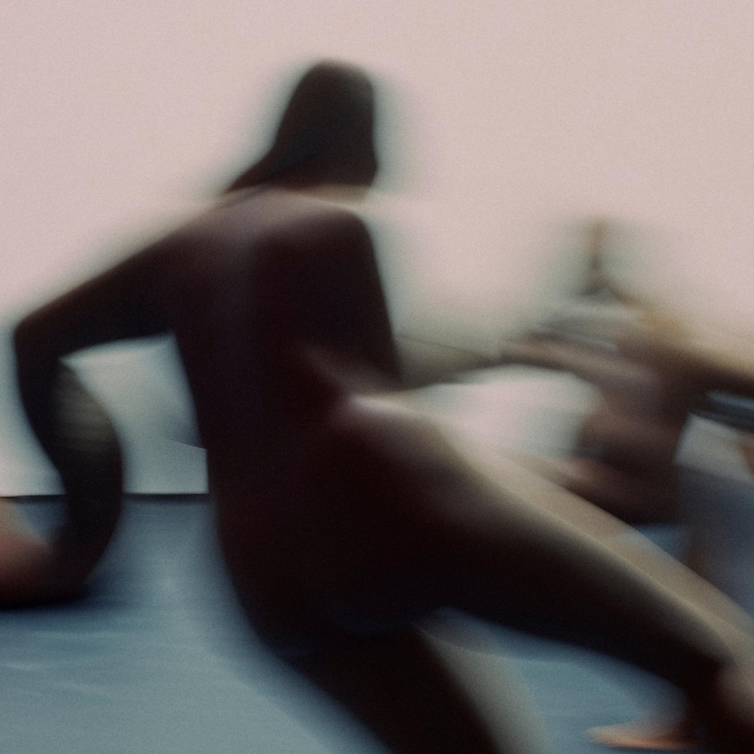 A blurry image of amorphous figures in motion.