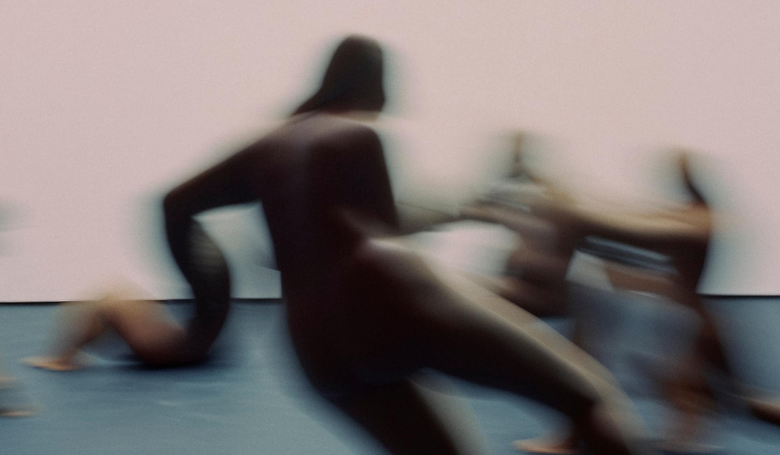 A blurry image of amorphous figures in motion.