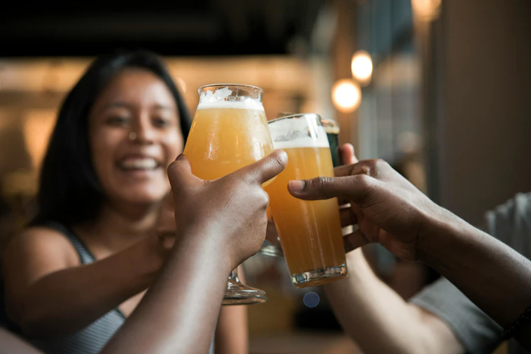 People clinking beer glasses together
