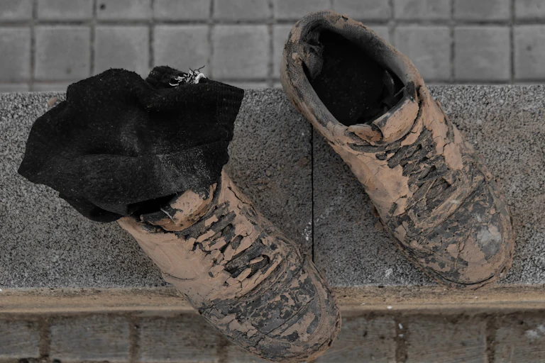 Dos botas completamente manchadas de barro.