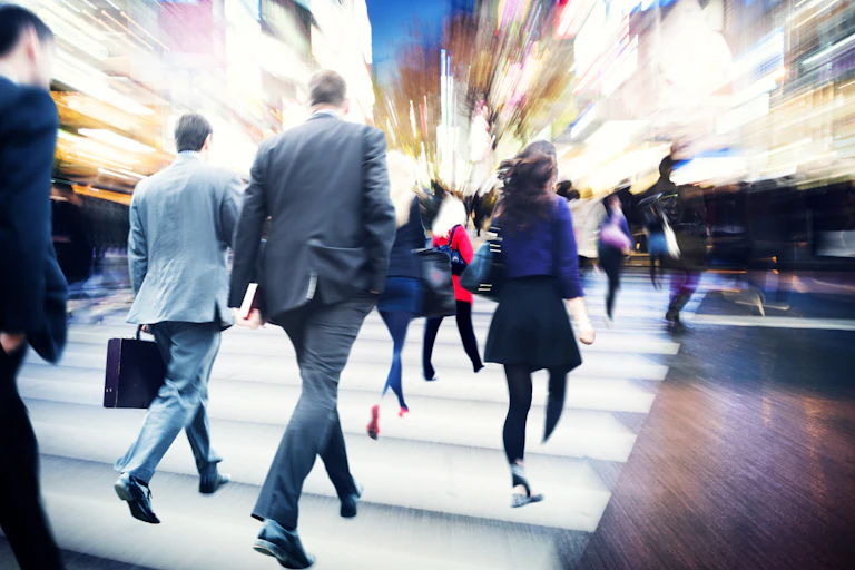 Male and female business people rushing across a street crossing