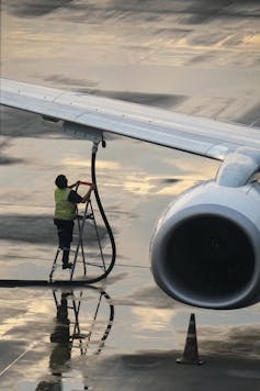 worker refueling a plane at an airport