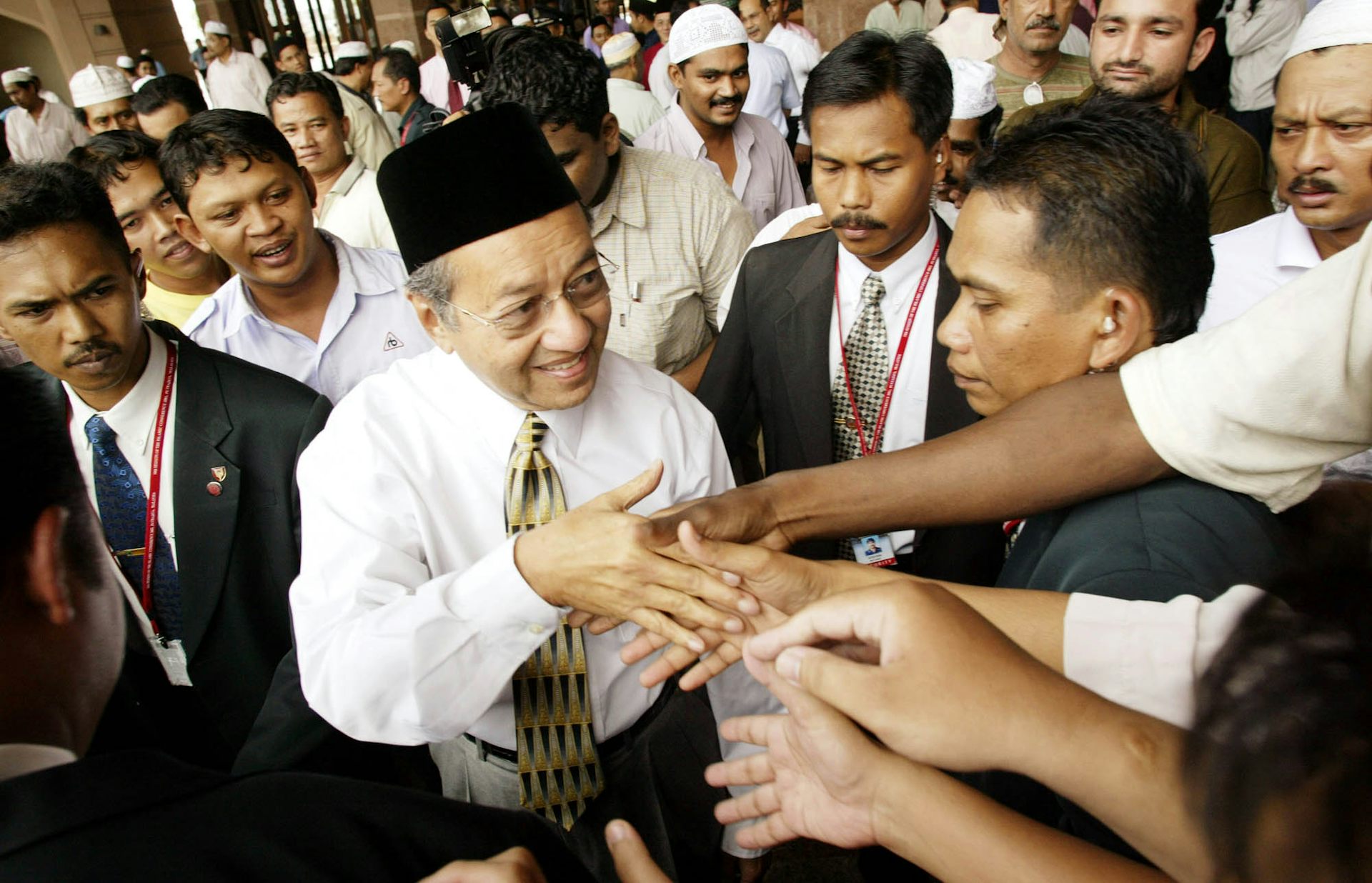 Malaysian Prime Minister Mahathir Mohamad shaking hands with worshippers.
