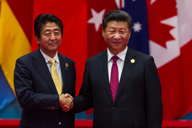 China's president, Xi Jinping, shaking hands with Shinzo Abe.